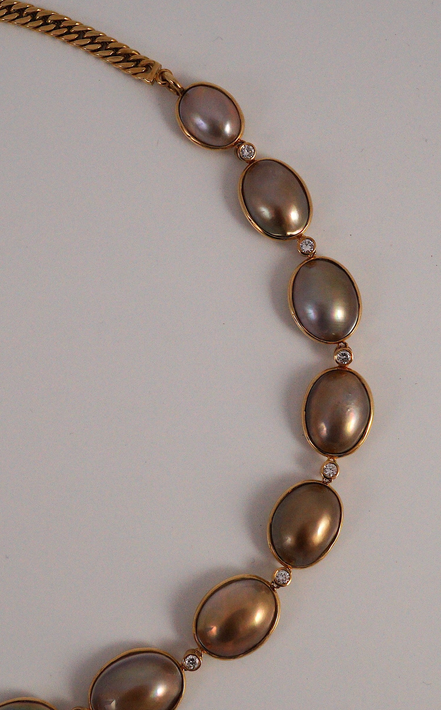 A cased modern single strand graduated shaped mabe pearl and round brilliant cut diamond set drop necklace, with 18ct gold clasp and chain section